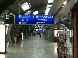 Auf dem Bild sind blaue Schilder im Flughafen die denn weg weißen