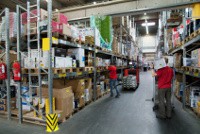 Ein Bild von einem Lager wo ein Mensch Sachen aus dem regal holt